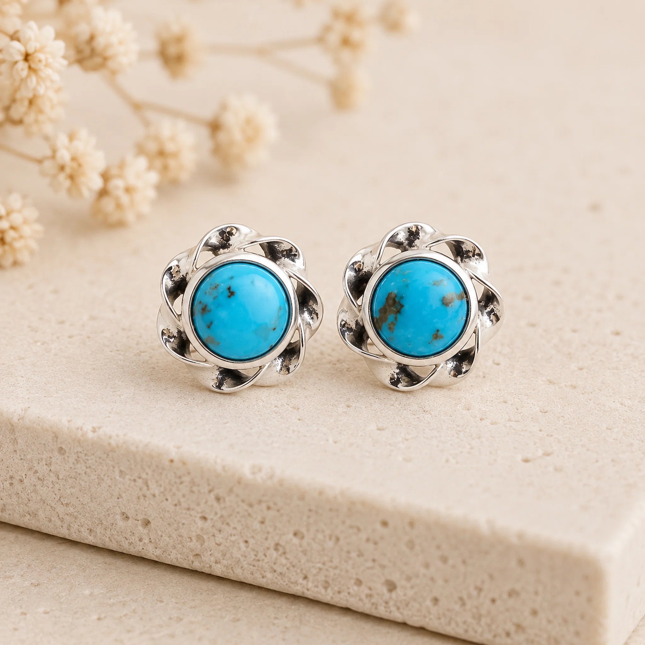 pair of sterling silver stud earrings with bezel set turquoise stones
