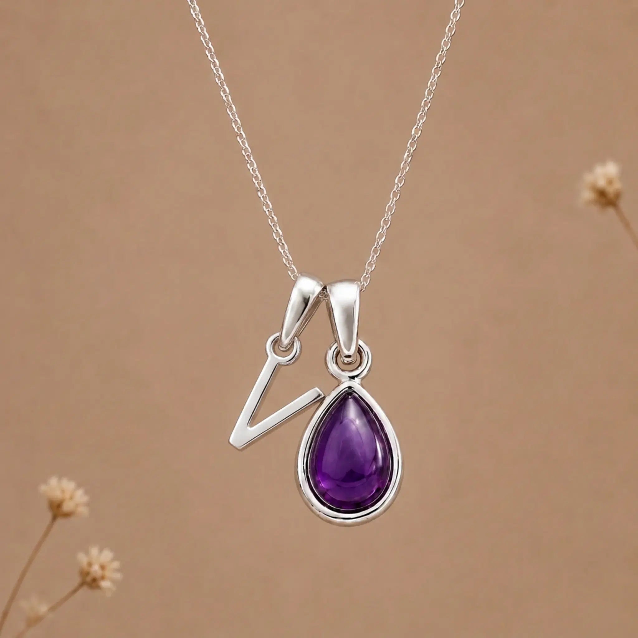 sterling silver initial v february birthstone natural amethyst pendant necklace against a dark warm beige background