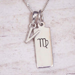 sterling silver initial v virgo zodiac star sign pendant necklace against a light wooden background