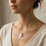 Close-up of a woman wearing a sterling silver necklace with a august birthstone peridot pendant and virgo zodiac pendant