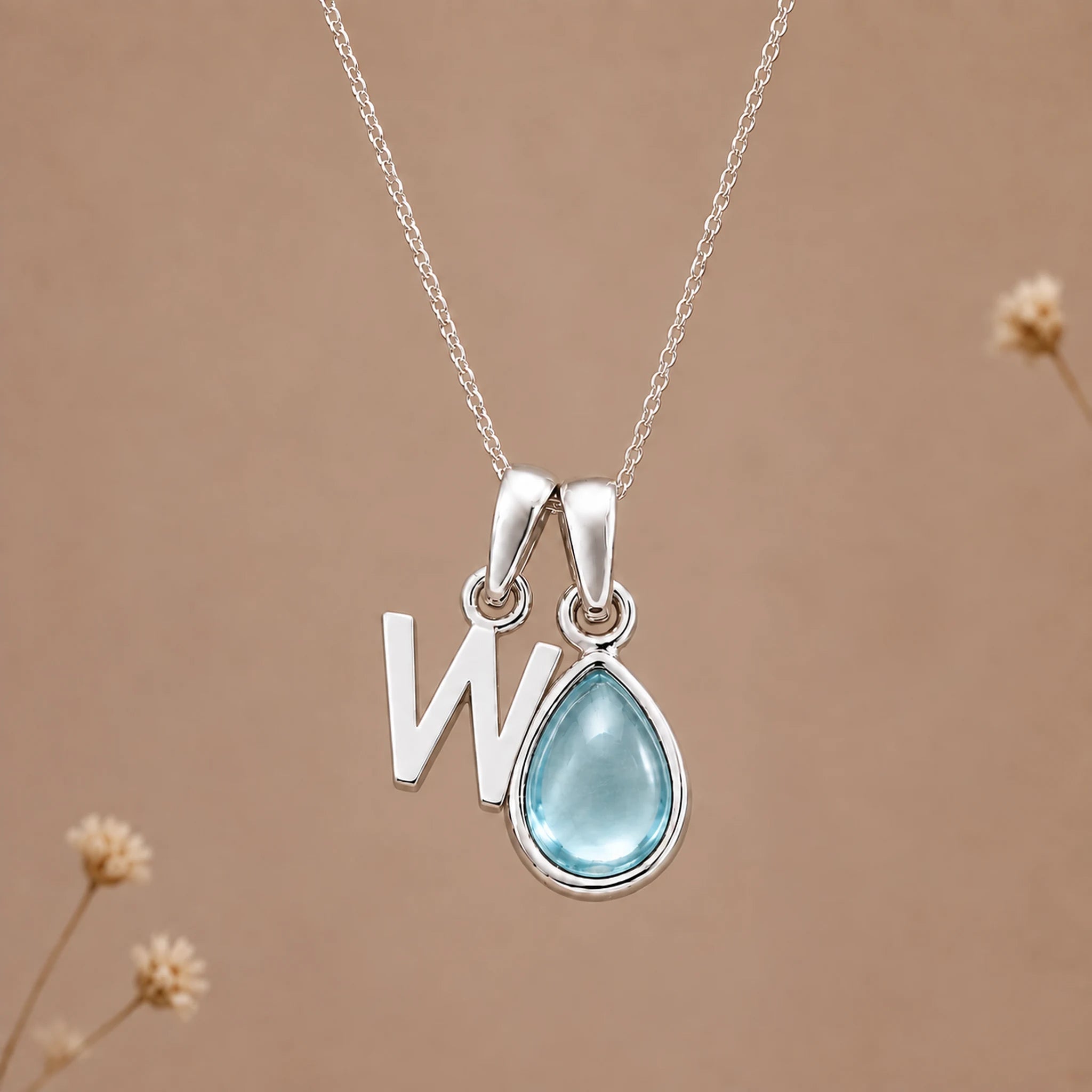 Sterling silver W initial necklace with pale blue March aquamarine in a polished teardrop bezel