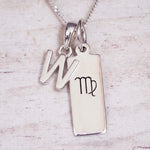 sterling silver initial w virgo zodiac star sign pendant necklace against a light wooden background
