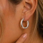 close up of woman wearing a stainless steel silver waterproof hoop earring