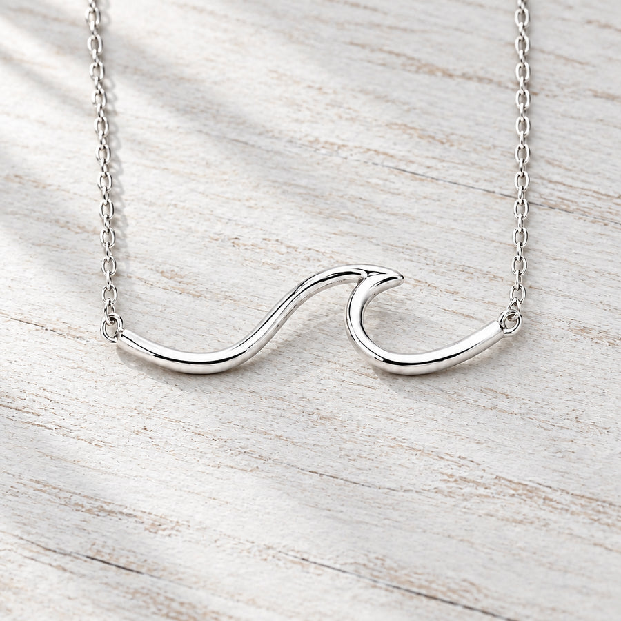 Sterling silver wave necklace on wood with dried pampas grass