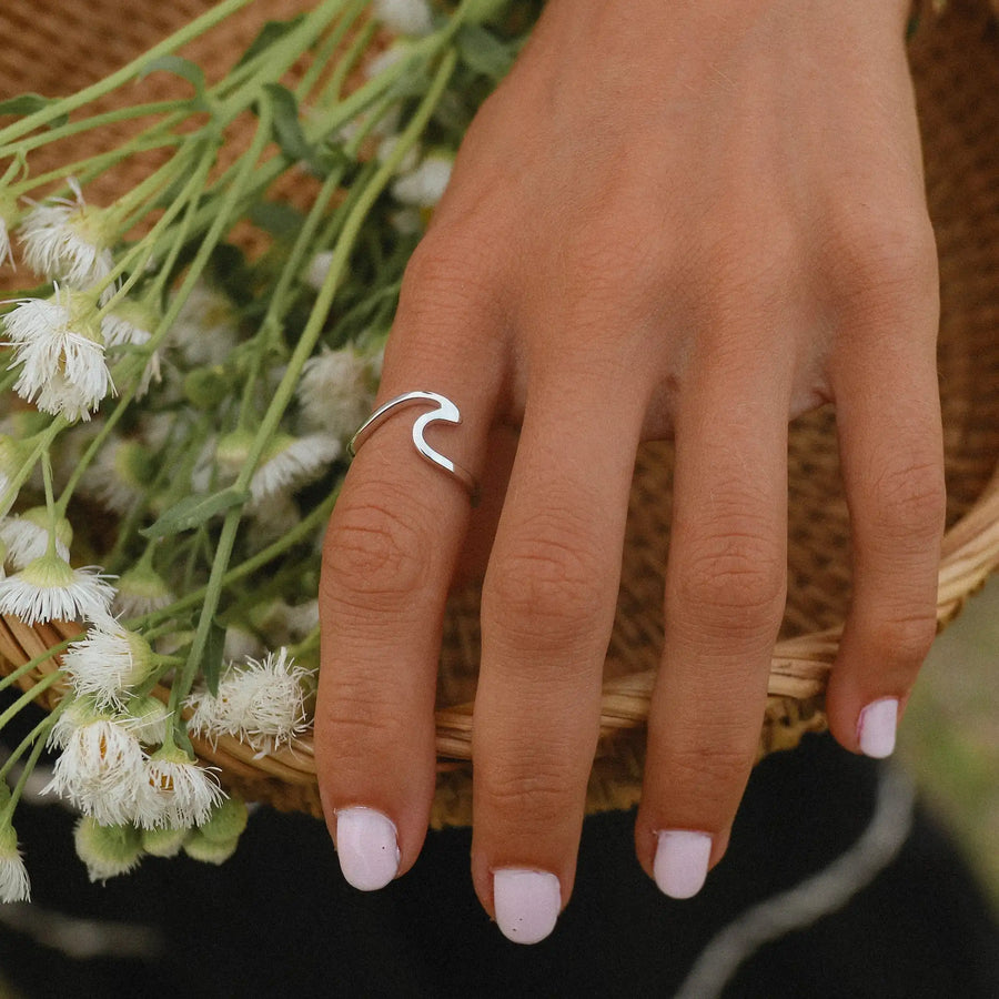 woman wearing sterling silver ring in the shape of a wave
