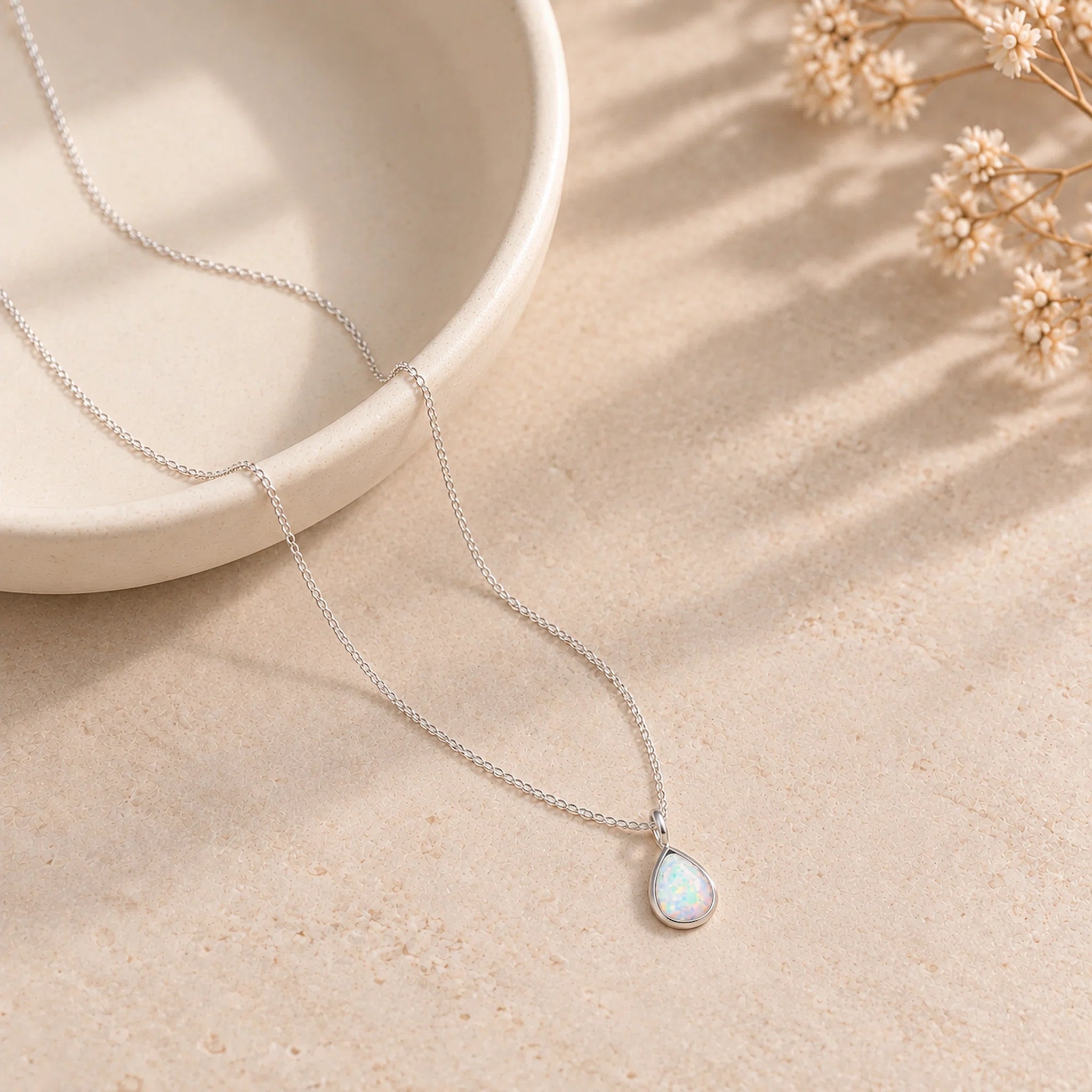 dainty sterling silver chain necklace with a pear-shaped white opal pendant