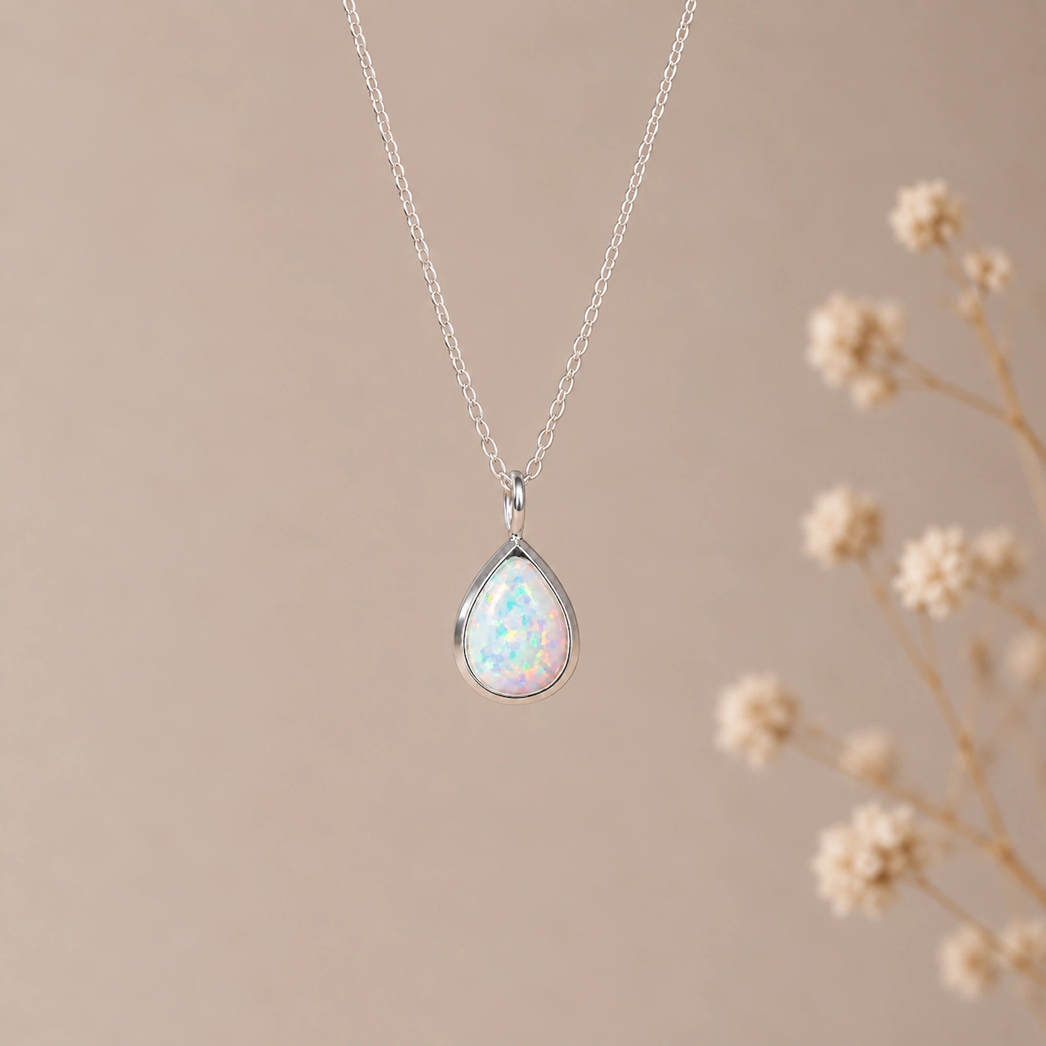 sterling silver fine chain with a pear-shaped bezel set cabochon lab-grown white opal pendant