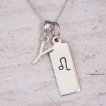 sterling silver initial y leo zodiac star sign pendant necklace against a light wooden background