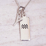 Sterling Silver Y Initial and Aquarius Necklace on a fine silver chain against a light wooden background