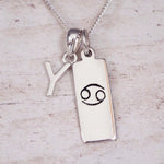 Sterling Silver Y Initial Cancer Zodiac Star Sign Necklace on a fine silver chain against a light wooden background