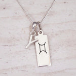 Sterling silver Y initial and GeminI Necklace on a fine silver chain on a light wooden background