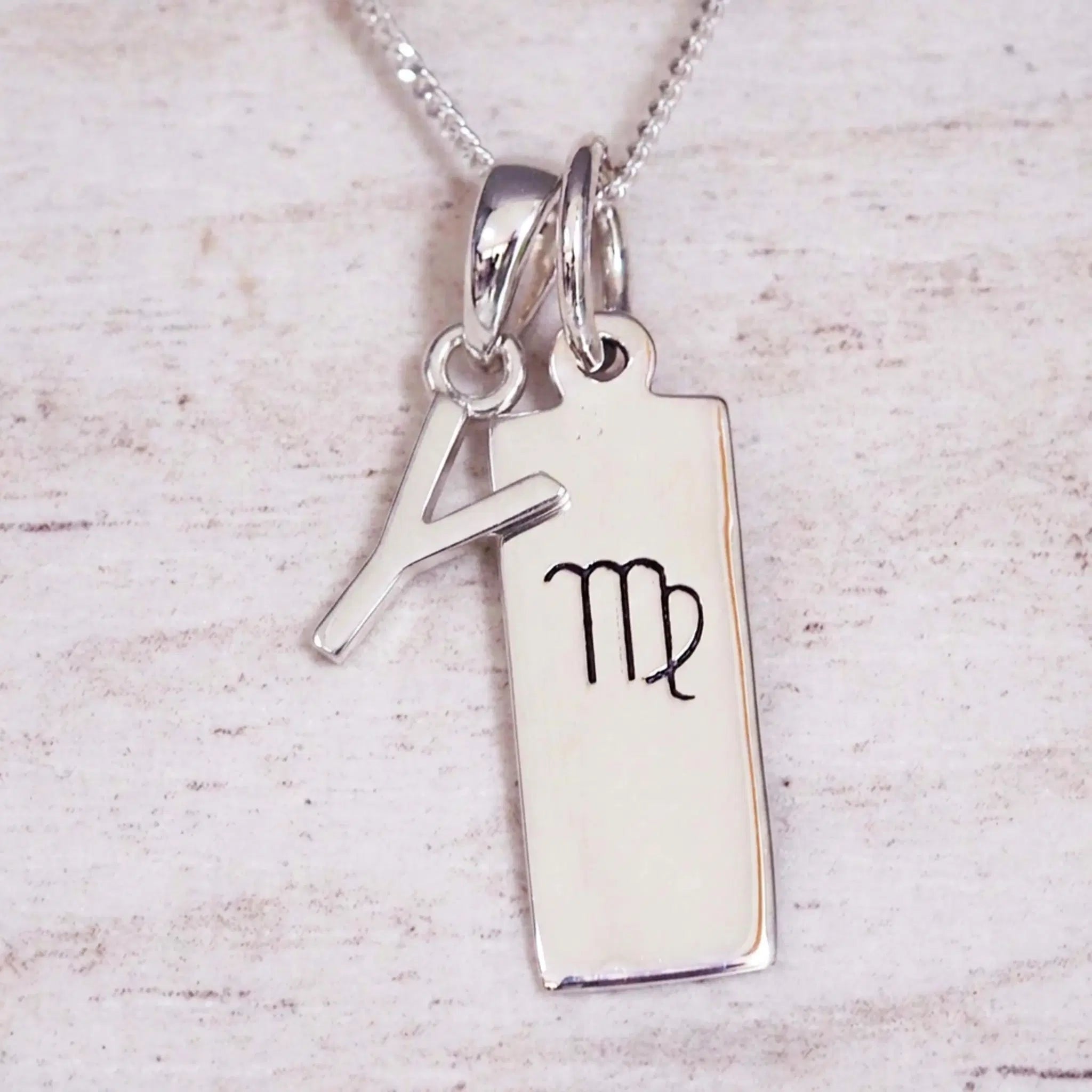 sterling silver initial y virgo zodiac star sign pendant necklace against a light wooden background