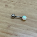 Barbell with a round gemstone on a wooden surface