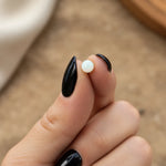 waterproof opal ball back stud earring being held