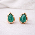 Teardrop-shaped green natural emerald gemstone stud earrings with rose gold frames on a white background