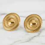 Pair of gold earrings on a marble surface