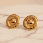 Gold earrings with a neutral background