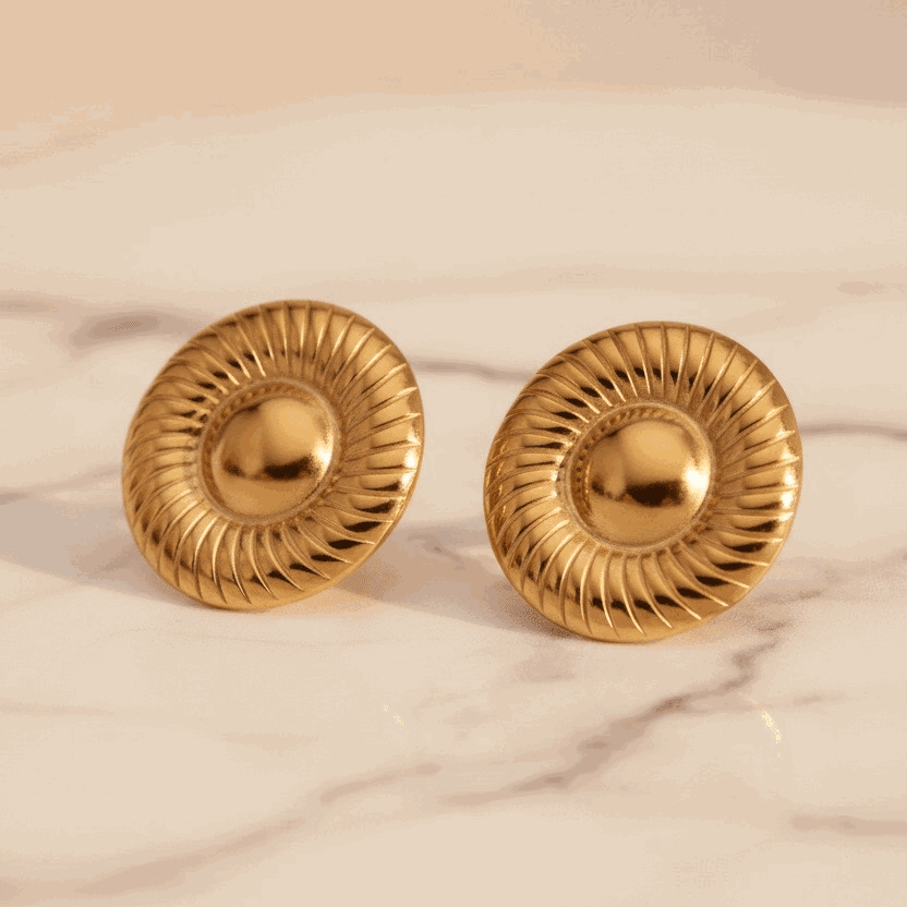 Gold earrings with a neutral background