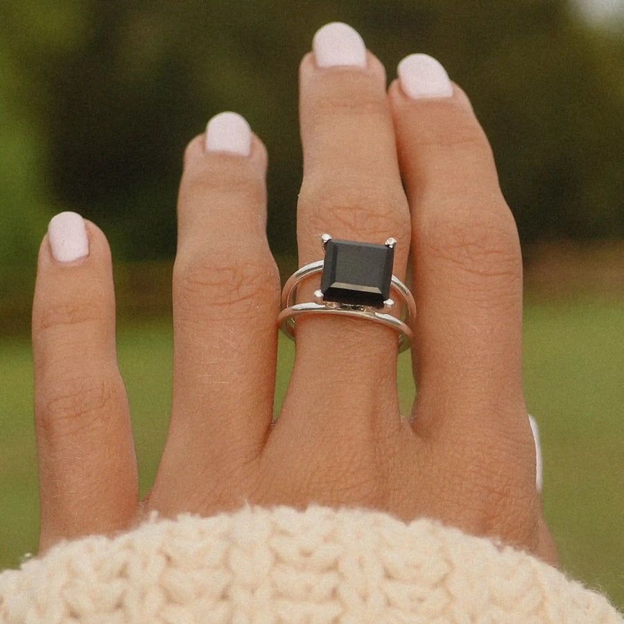 woman wearing sterling silver ring with square black onyx stone in the middle