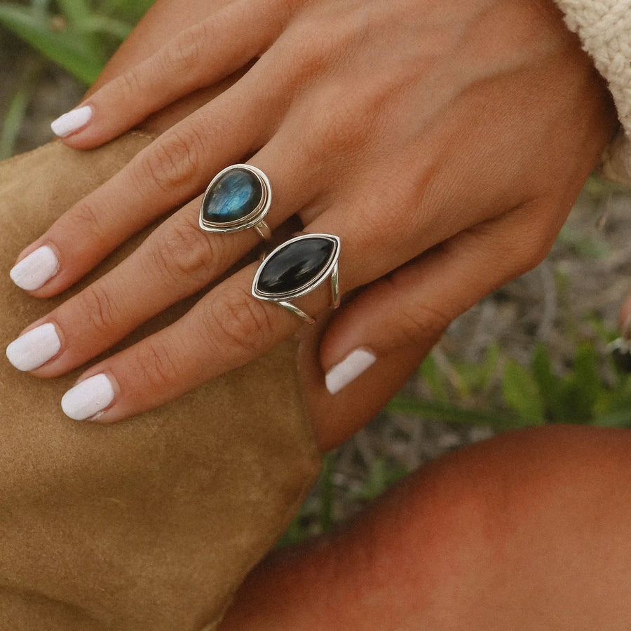 woman wearing two sterling silver rings, one with a labradorite stone and the other with a large black onyx stone - boho jewelry