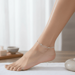 Silver anklet on a foot with a blurred background