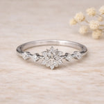 sterling Silver ring with snowflake celestial design with clear coloured cubic zirconia gemstones on a beige background