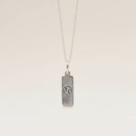 Silver necklace with a cancer zodiac pendant on a beige background