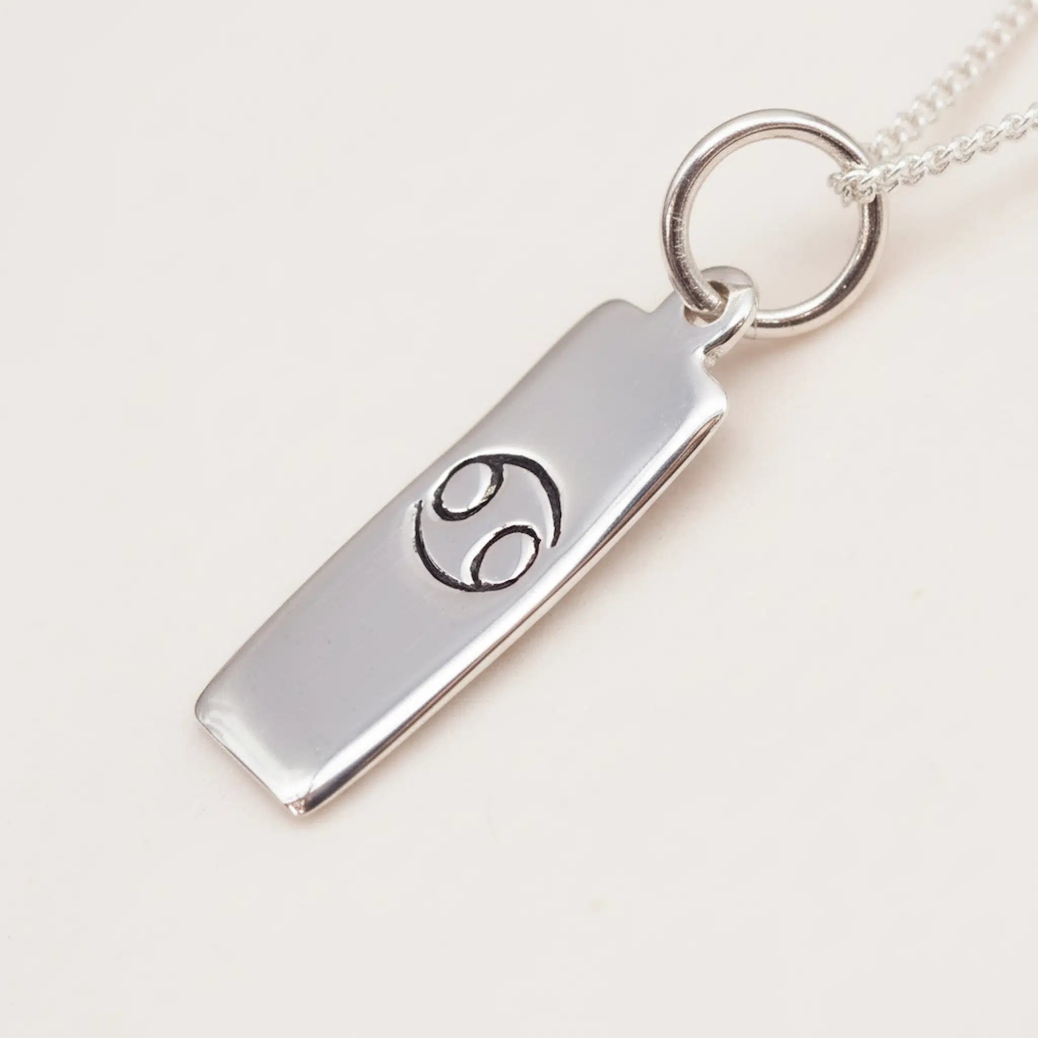 Sterling Silver Cancer Zodiac Pendant Necklace on a white surface