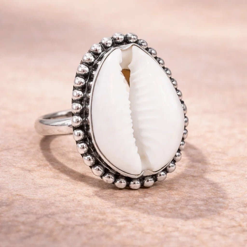 Ring with a white shell in the center on a wooden surface