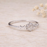 Sterling Silver ring with snowflake celestial cubic zirconia gemstone design on a beige background