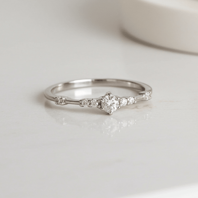 Silver ring with small cubic zirconias on a white surface