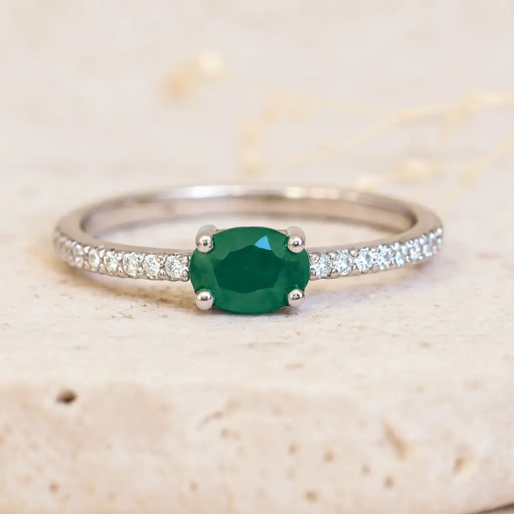 sterling silver Ring with a green emerald gemstone on a beige background
