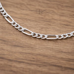 Silver chain necklace on a wooden surface