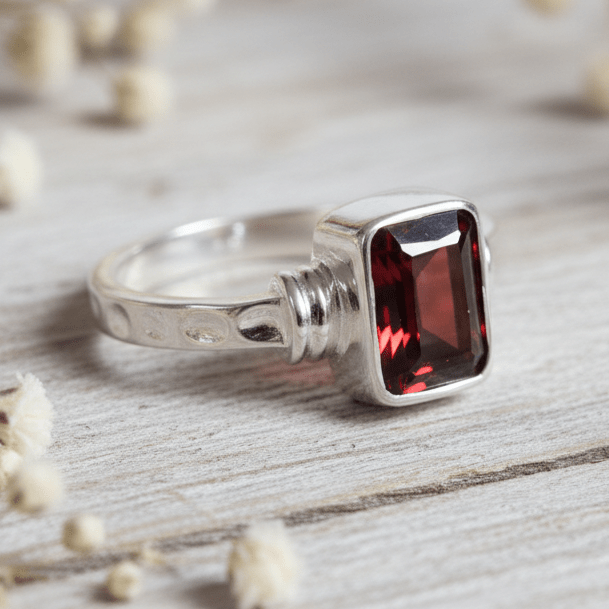 Sterling Silver ring with a red Garnet gemstone on a white background by indie and harper