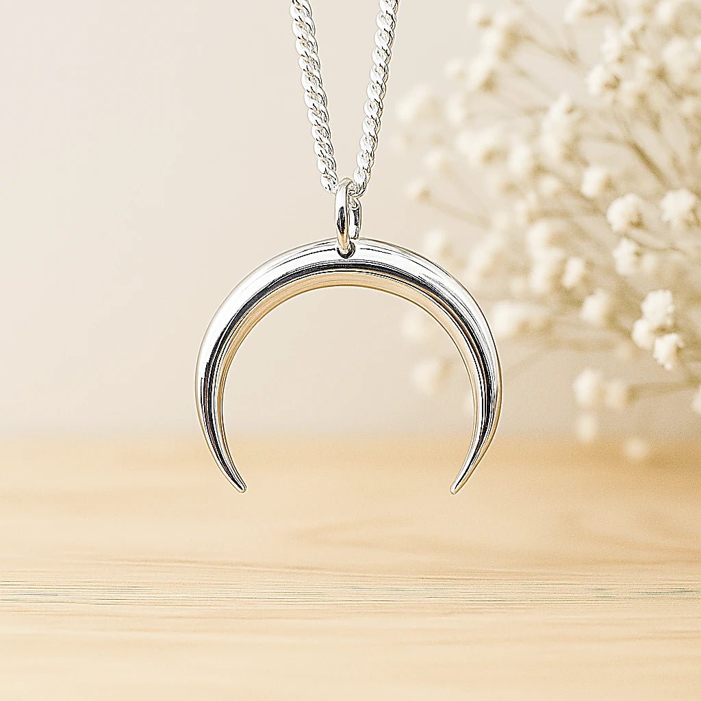 sterling Silver crescent moon necklace on a neutral background
