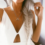 Woman with braided hair wearing a sterling silver necklace with a crescent moon pendant.
