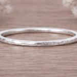 sterling Silver hammered stacker ring macro on a wooden surface