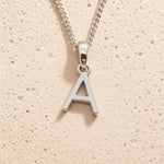 Sterling Silver Initial Necklace with a minimalist A charm pendant on a light stone background