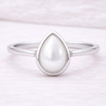 sterling Silver ring with a teardrop-shaped pearl on a light pink background