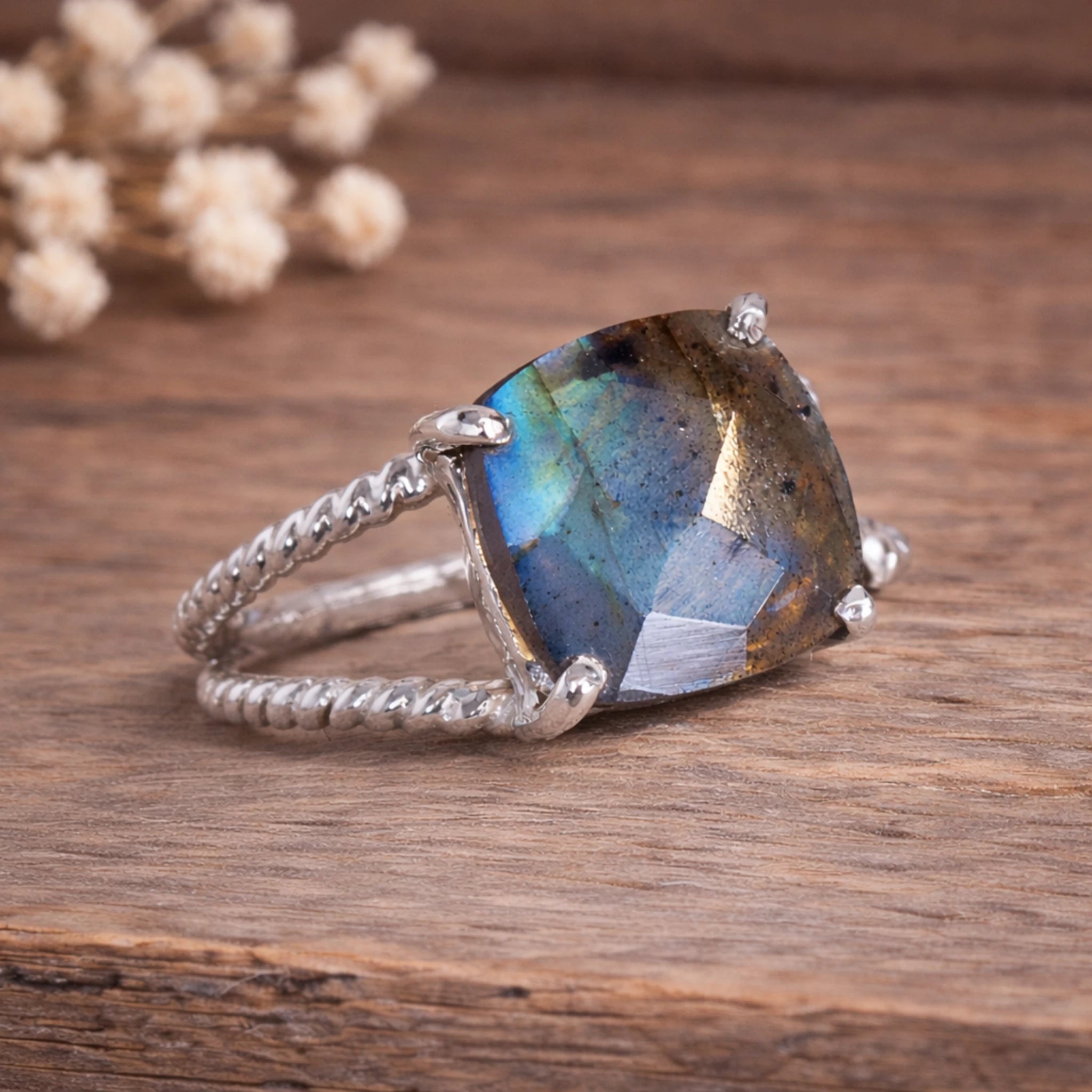 sterling Silver labradorite ring with a large, faceted natural labradorite gemstone on a wooden surface.