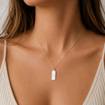 sterling silver fine chain Necklace with a libra star sign line glyph rectangle pendant worn by a person