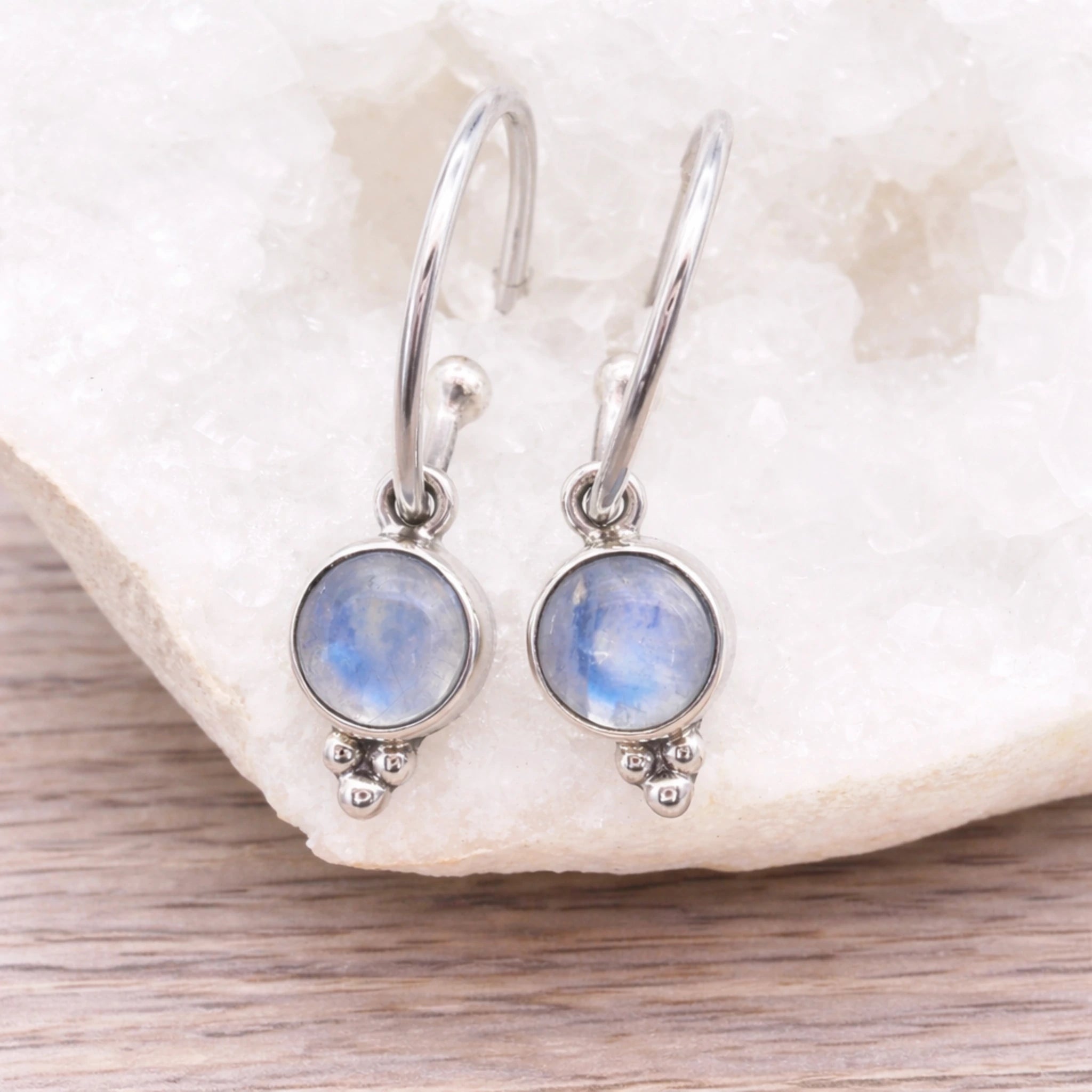 Sterling Silver Moonstone Hoop earrings on a crystal stone surface