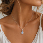 sterling silver natural moonstone necklace worn featuring a larger pear-shaped cabochon bezel-set pendant

