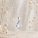 sterling silver moonstone necklace featuring a natural moonstone cabochon, bezel-set and pear-shaped pendant on a fine curb chain