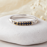 sterling Silver ring with natural blue sapphire stones on a white stone with dried flowers in the background
