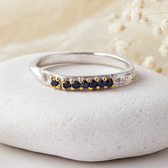 sterling Silver ring with natural blue sapphire stones on a white stone with dried flowers in the background
