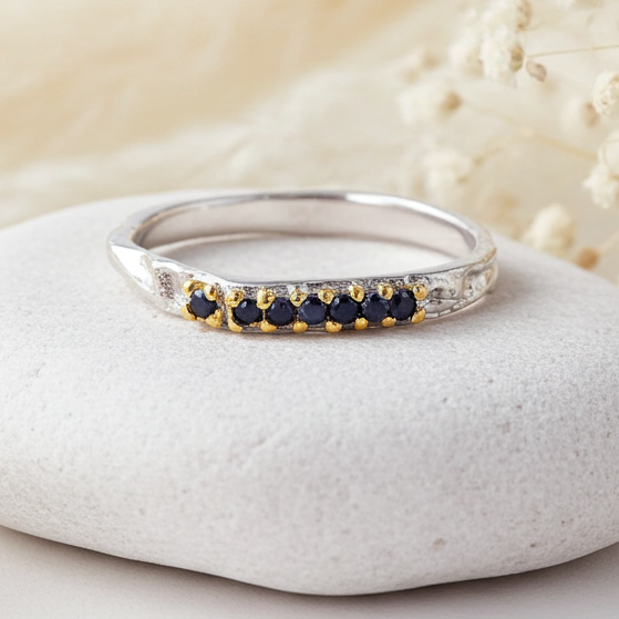 sterling Silver ring with natural blue sapphire stones on a white stone with dried flowers in the background
