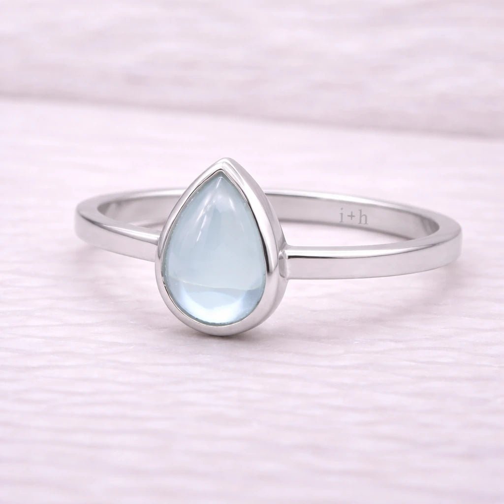 Sterling Silver ring with a teardrop-shaped light blue natural topaz gemstone on a white background
