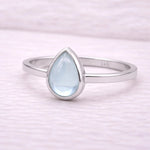 Sterling Silver ring with a teardrop-shaped light blue natural topaz gemstone on a white background