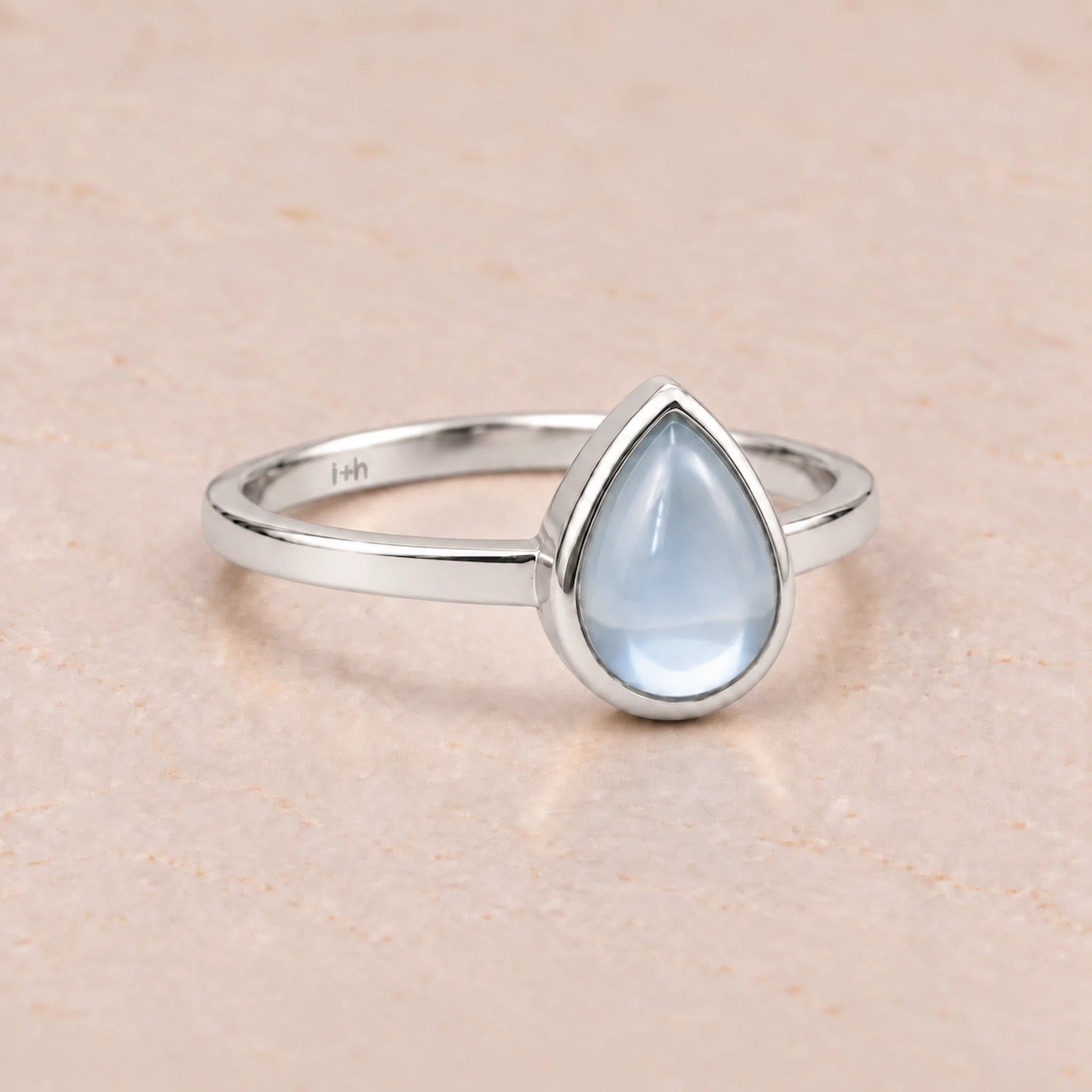 Sterling Silver November birthstone ring with a teardrop-shaped light blue natural topaz gemstone on a white background